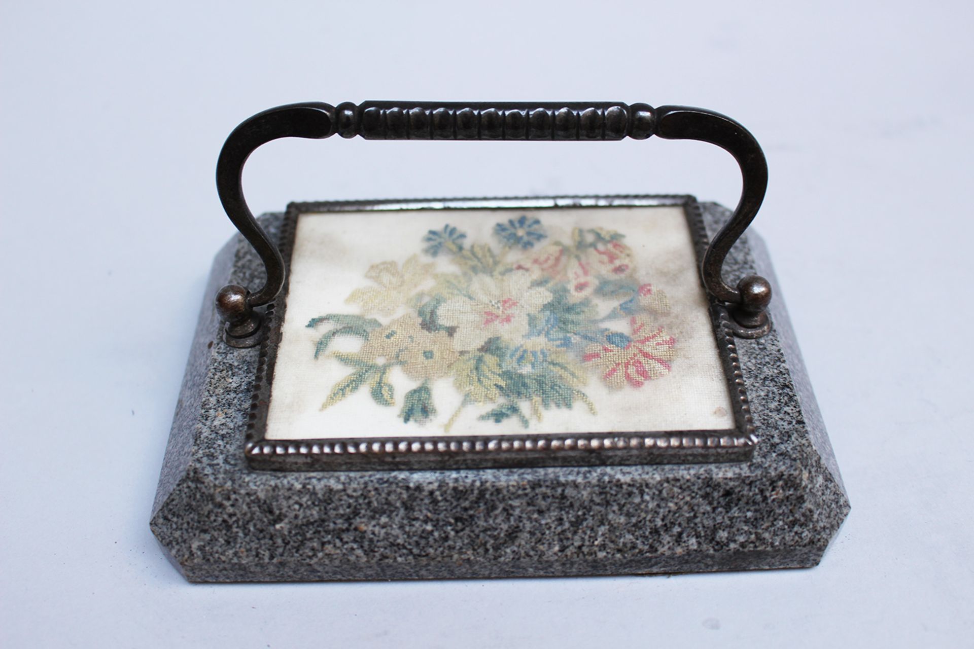 Vienna paperweight, cut iron mount with needlework picture on grey granite stone base; around