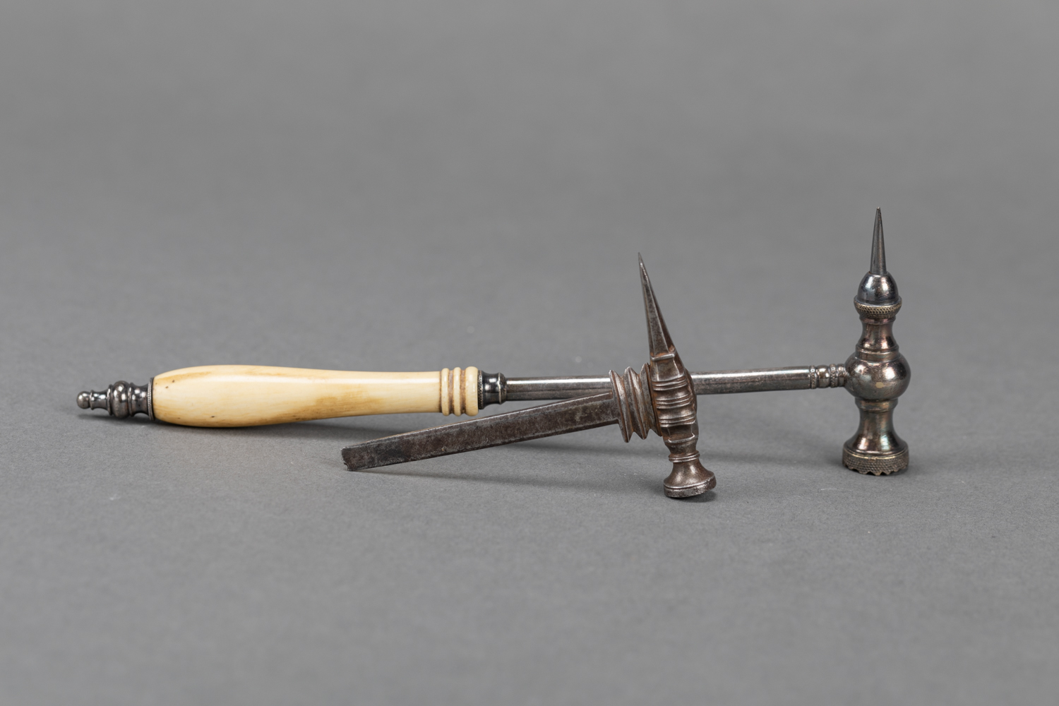 two miniature tools in form of hammers, I and Iron,