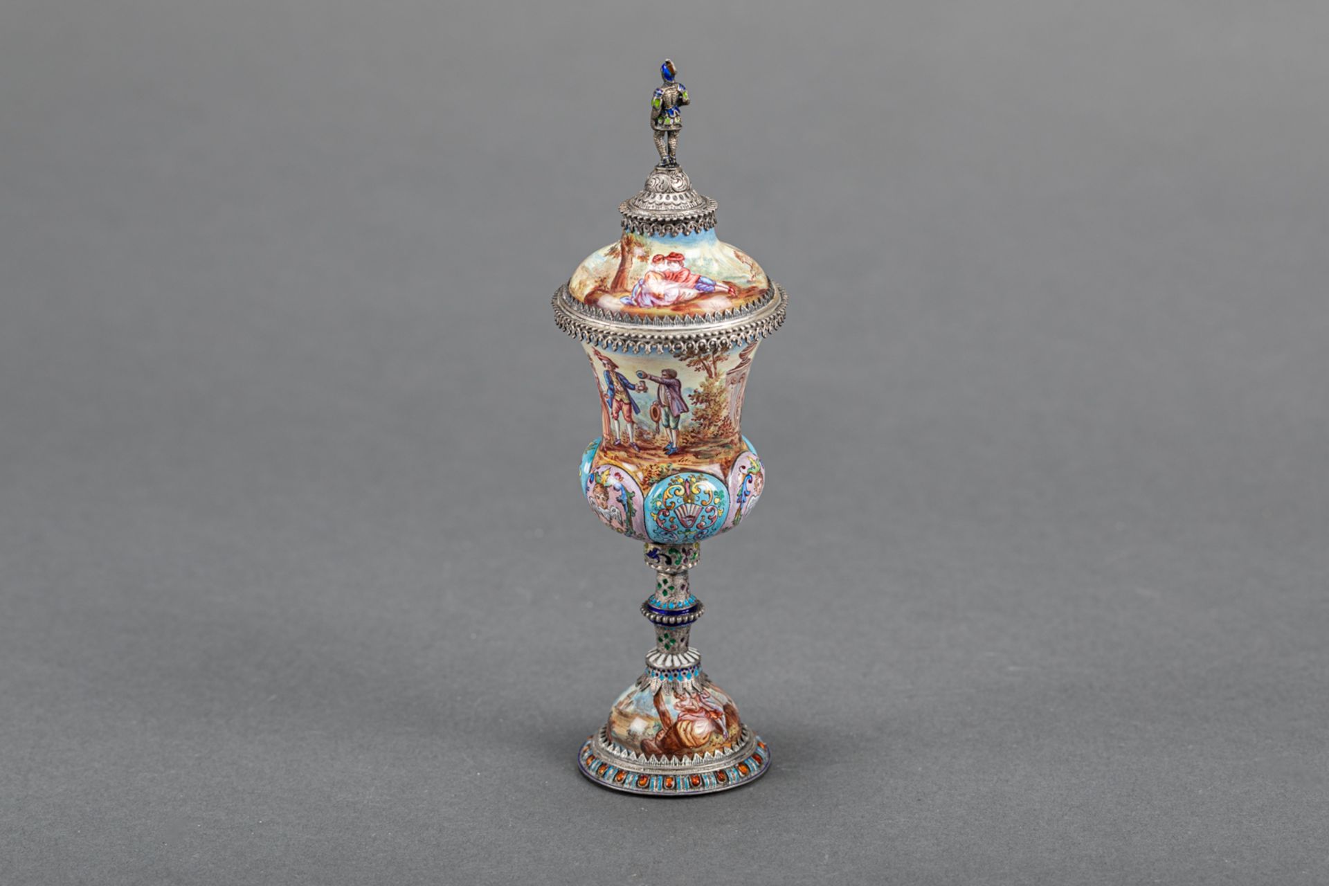 Vienna enamel goblet with lid, on central feed , silver mount with multi coloured enamel scenes