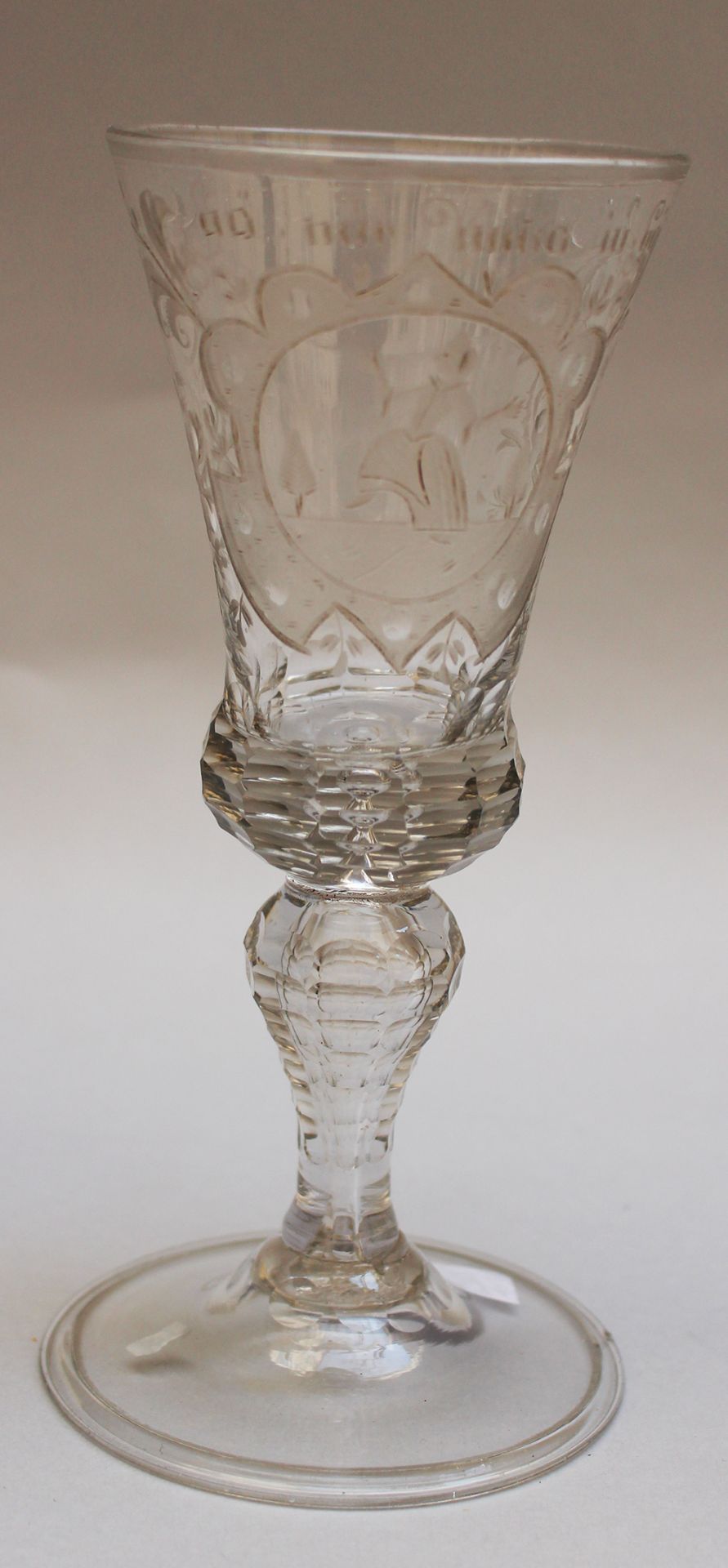 Transparent glass goblet, with one cut and curved central foot, with etched ornament and described “