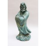 Chinese ceramic sculpture of a guardian in folded mantle on cloud, hand formed with blue glaze