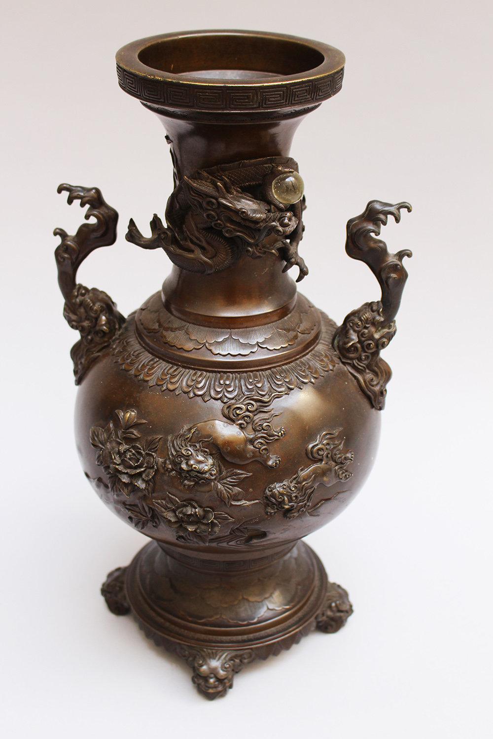 Chinese Bronze vase in urn shape on central feed with long neck and two handgrips, bronze cast