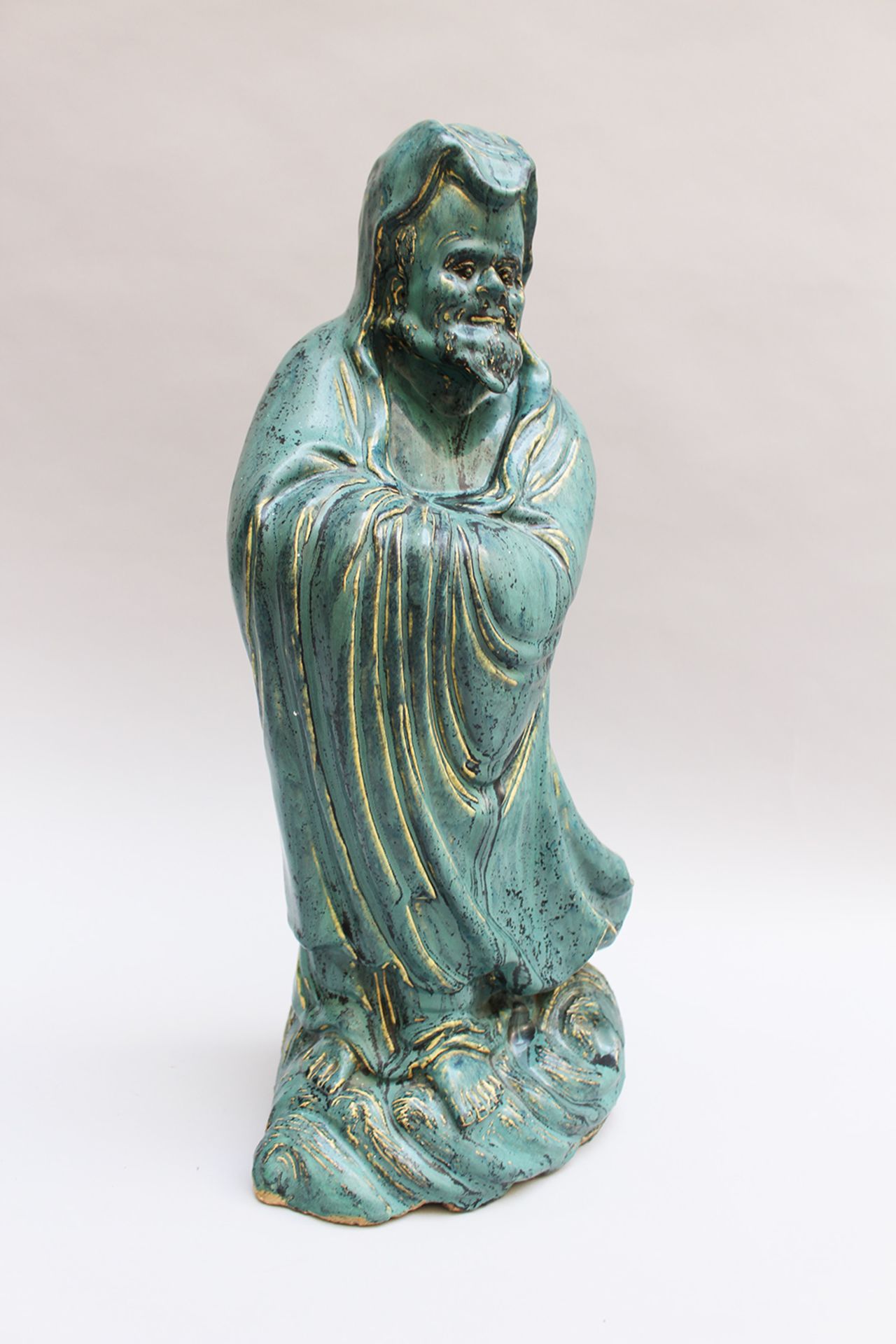 Chinese ceramic sculpture of a guardian in folded mantle on cloud, hand formed with blue glaze - Image 2 of 3