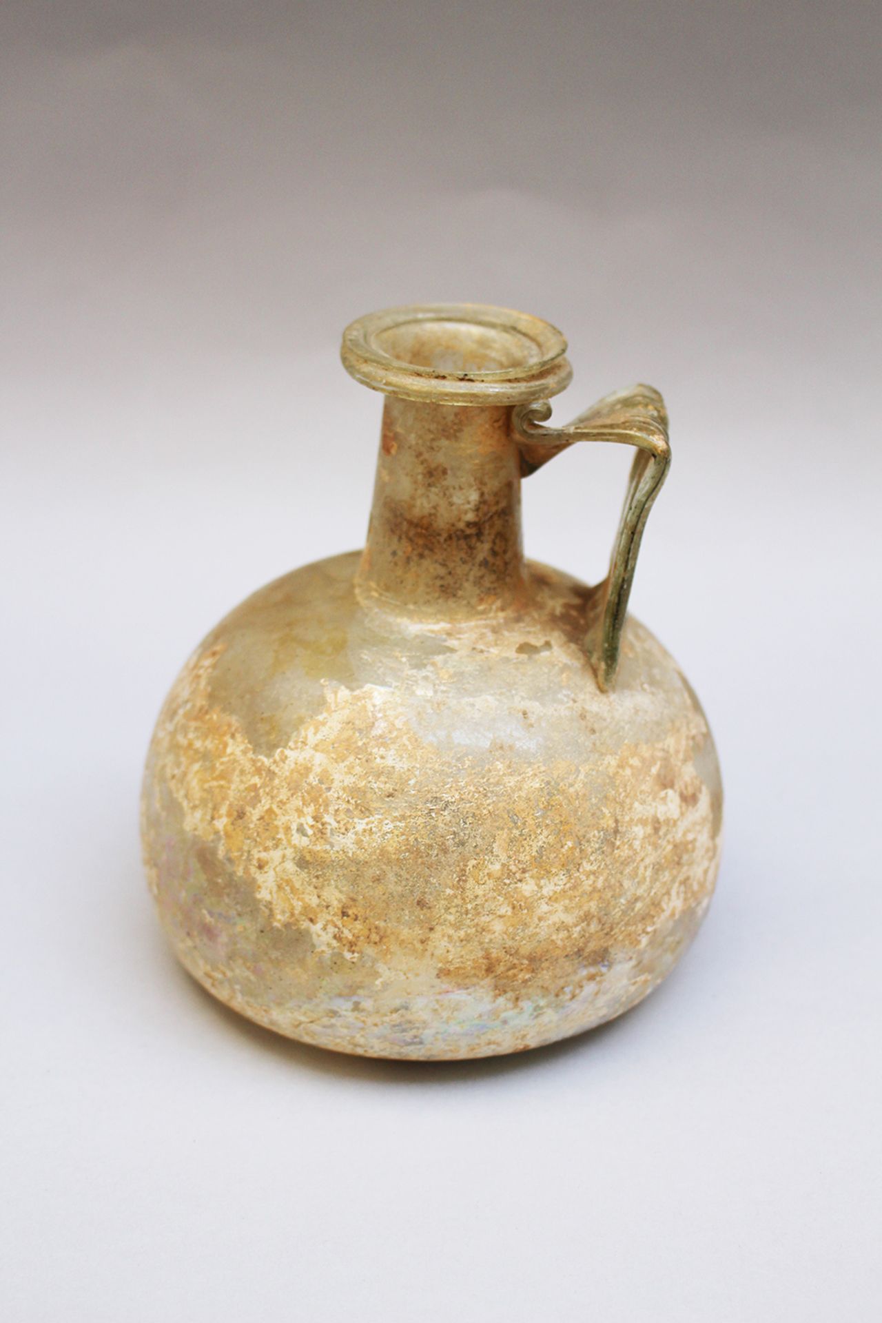 Early glass flask , round shape with handgrip and long neck, green transparent glass , possible