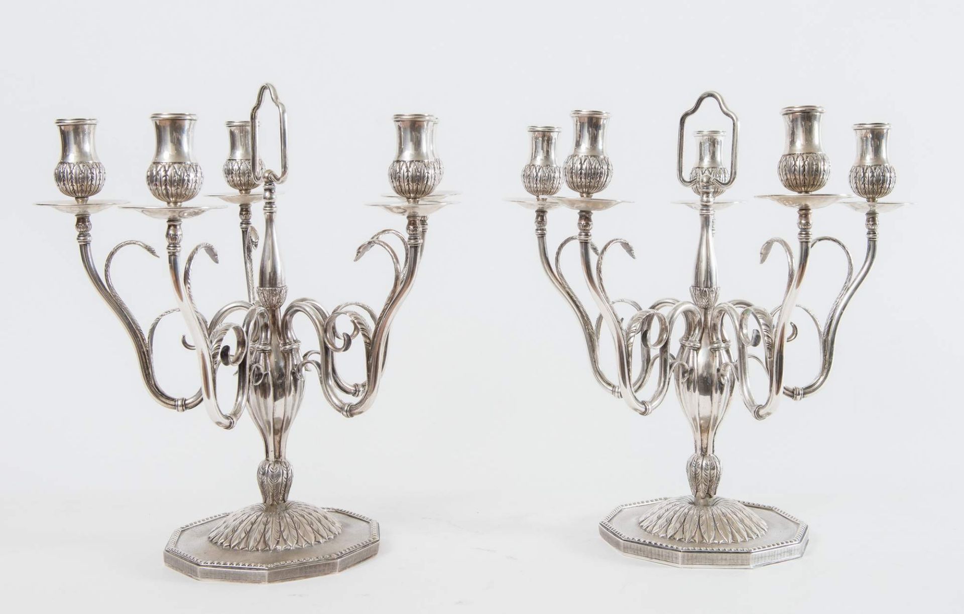 Coppia di candelabri in argento 800. Sotto la base recano punzoni: 800, lasanga locativa, stemma.