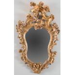 Specchiera in legno dorato e finemente intagliato. Emilia, XIX secolo. Presenta forma mistilinea con