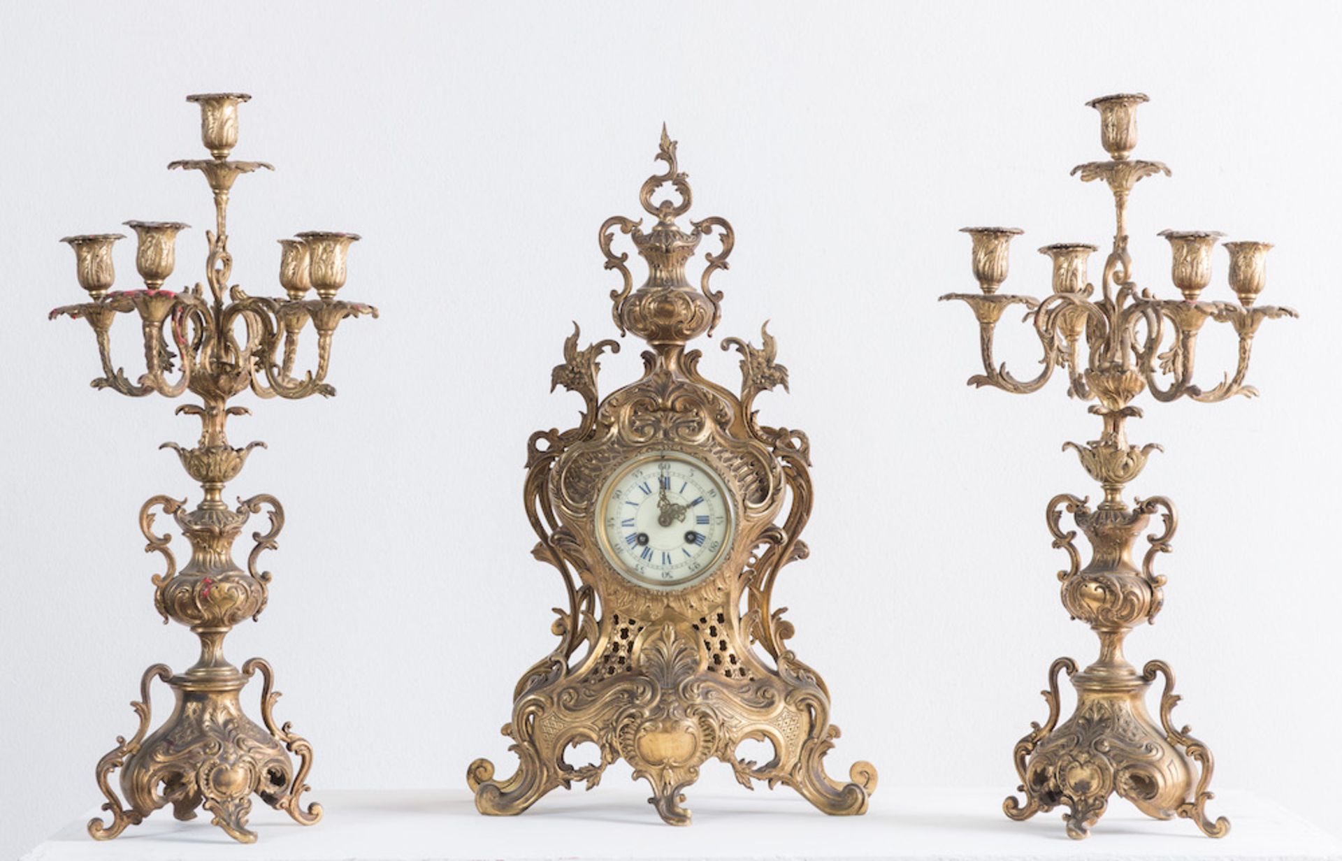 Trittico in bronzo, composto da coppia di candelabri e orologio. Di gusto Luigi XV, realizzata