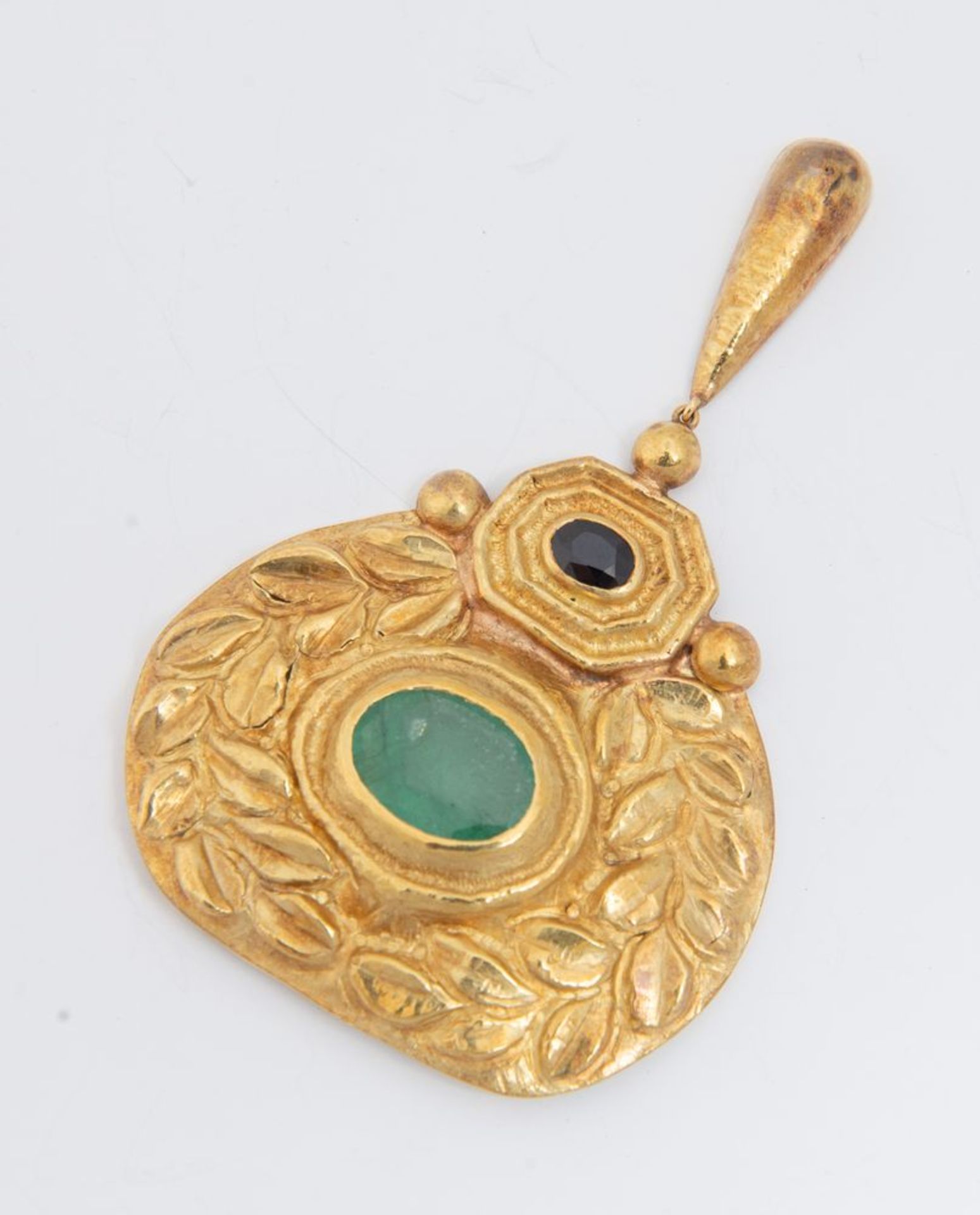 Pendente in oro, zaffiro e smeraldo.
Realizzato come un medaglione sbalzato e inciso a motivi vegeta - Bild 2 aus 3