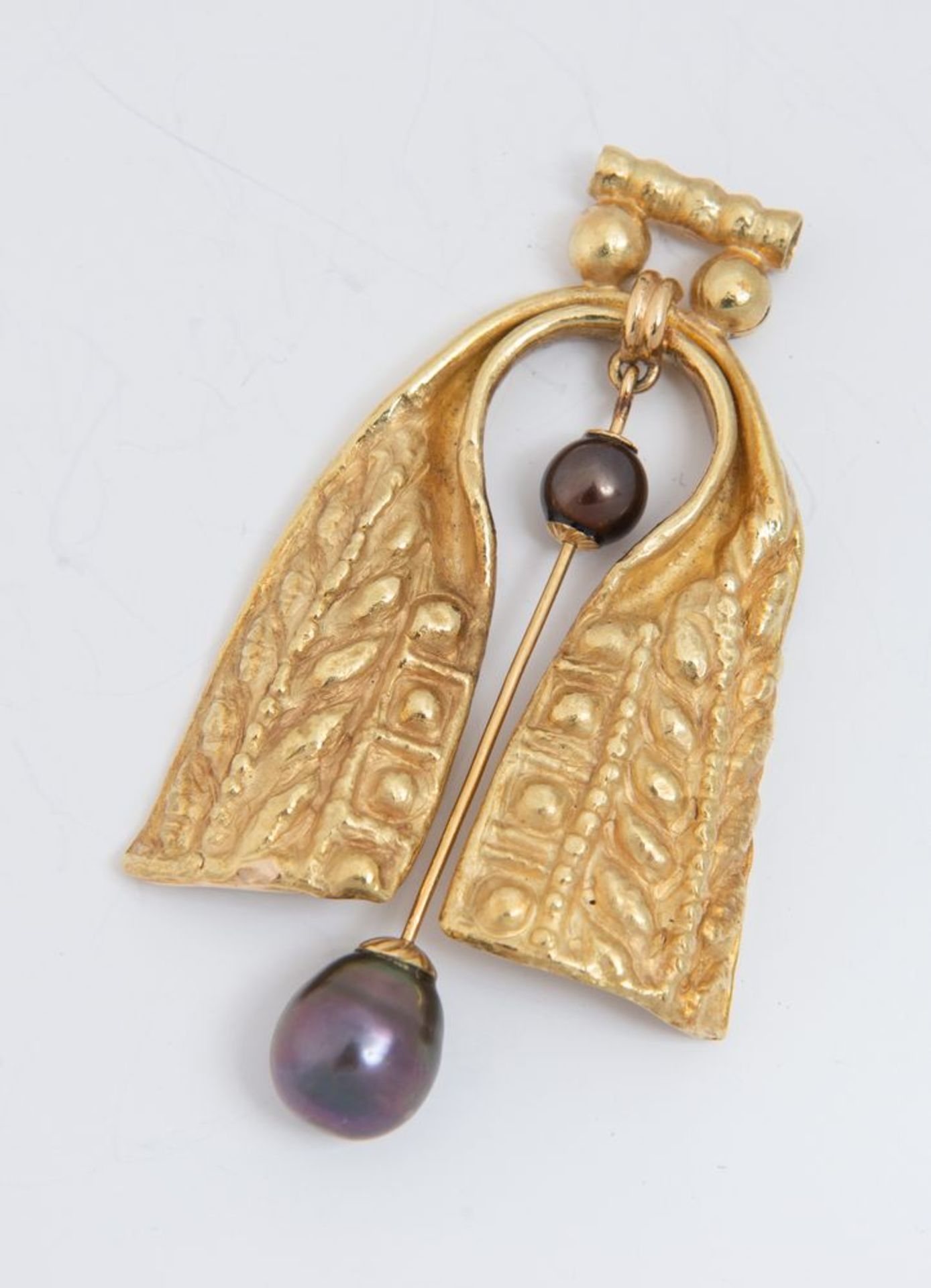 Pendente in oro e perle.
In oro sbalzato e inciso, al centro elemento snodato decorato con due perle - Bild 3 aus 3