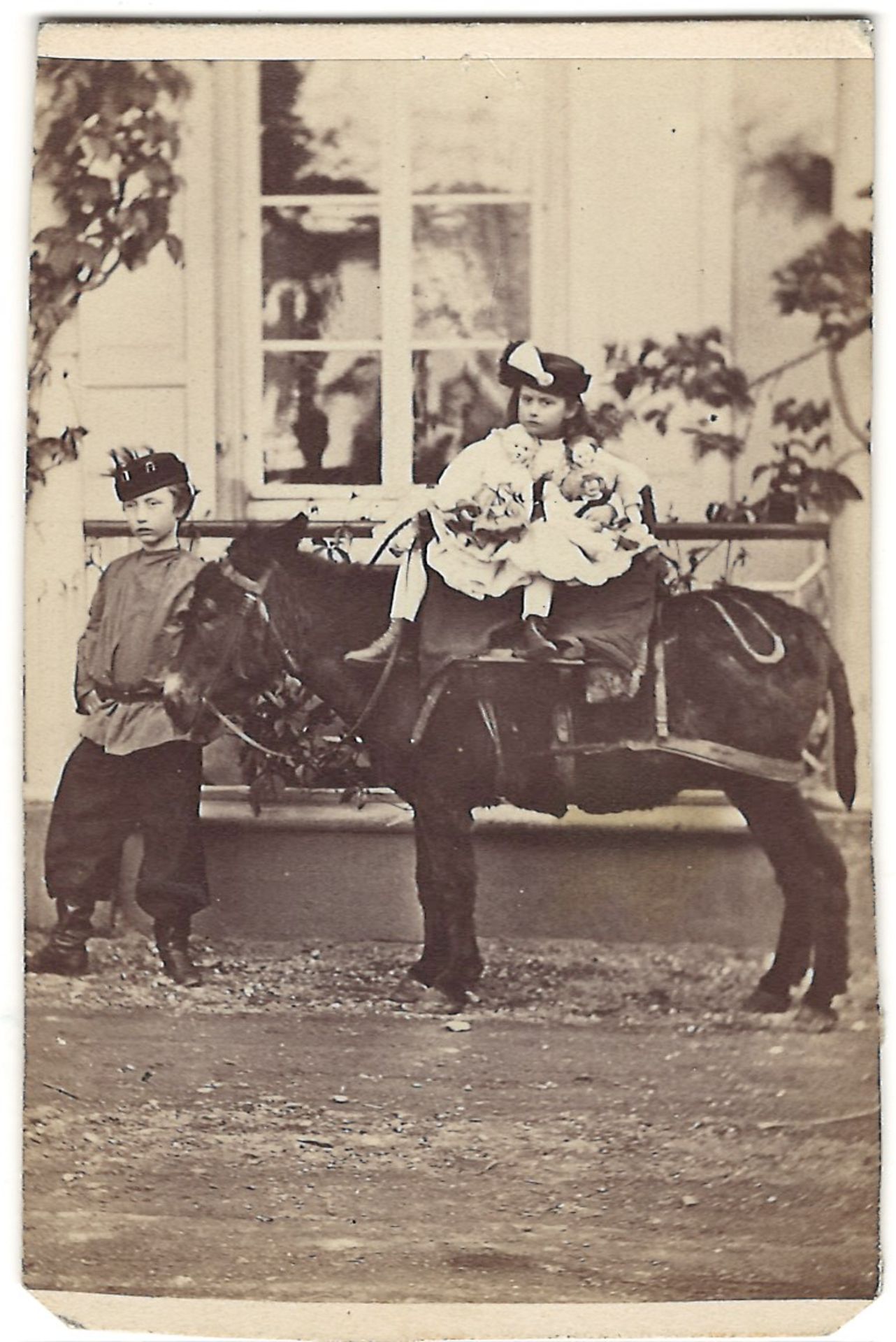 Kaufmann, L. Children and ponies. Photoprint. [Late 19th century]. 9,8x6,2 cm.<br>9,8x6,2 cm.