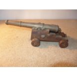 A BRASS BARRELED MODEL OF AN EARLY 19TH CENTURY NAVAL CANNON MOUNTED ON A WOODEN CARRAIGE, LENGTH OF