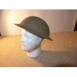 A WORLD WAR II PERIOD BRITISH STEEL HELMET AND LINER