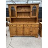 A DUCAL PINE DRESSER WITH FOR LOWER DOORS AND DRAWERS AND UPPER PLATE RACK WITH TWO GLAZED DOORS -
