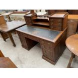 A LATE VICTORIAN 'CARLTON HOUSE' STYLE OAK DESK, THE BASE ENCLOSING NINE DRAWERS, THE UPPER