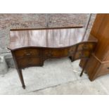 A 19TH CENTURY STYLE SERPENTINE FRONTED DESK ENCLOSING ONE LONG AND FOUR SHORT DRAWERS, ON TAPERED