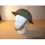 A WORLD WAR II PERIOD BRITISH STEEL HELMET AND LINER