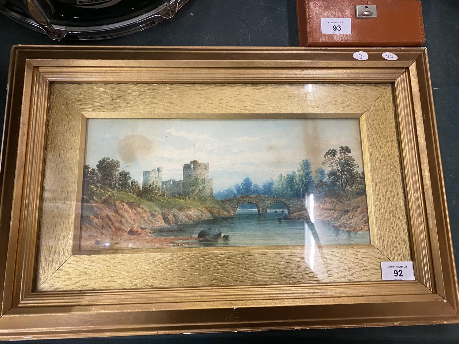 A FRAMED WATERCOLOUR OF A CASTLE AND RIVER SCENE