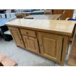 A MODERN OAK SIDEBOARD ENCLOSING SINGLE DRAWER AND THREE CUPBOARDS, 68" WIDE