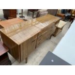A 'BEAUTILITY' ROSEWOOD EFFECT SIDEBOARD ENCLOSING FOUR DRAWERS AND TWO CUPBOARDS, ON TAPERED LEGS
