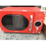 A RED DAEWOO MICROWAVE OVEN BELIEVED IN WORKING ORDER BUT NO WARRANTY