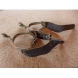 A PAIR OF SPURS WITH LEATHER STRAPS