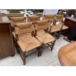A SET OF SIX JACOBEAN STYLE OAK DIN ING CHAIRS WITH RUSH SEATS AND BOBBIN TURNED STRETCHER RAILS