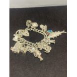 A SILVER CHARM BRACELET WITH SIXTEEN VARIOUS CHARMS TO INCLUDE A FISH, BIRD CAGE, BOAT ETC