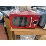 A RED DAEWOO MICROWAVE OVEN BELIEVED IN WORKING ORDER BUT NO WARRANTY