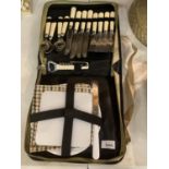 A CANVAS CASED PICNIC SET INCLUDING FLATWARE, BOTTLE/WINE OPENER, PLATES, NAPKINS ETC.