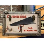 A TWIN HANDLED TRUNK DECORATED WITH 'GUINNESS' ADVERTISING MATERIAL