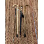 THREE WOODEN WALKING STICKS AND A VINTAGE UMBRELLA WITH BAMBOO HANDLE