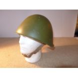 A GREEN PAINTED STEEL HELMET AND LINER