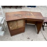 AN UNUSUAL MID CENTURY CURVED DESK WITH DROP DOWN ROLLER SHUTTER COMPARTMENT AND SHALLOW DRAWER -