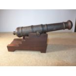 A LATE 19TH CENTURY CAST IRON SIGNALLING CANNON, 43CM BARREL MOUNTED ON A MAHOGANY FRAME