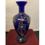 A BLUE GLASS URN WITH GOLD RELIEF FLOWER PATTERN (HEIGHT 26CM)