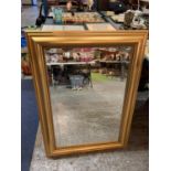 A LARGE GILT EDGE FRAMED WALL MOUNTED MIRROR