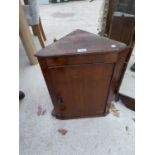 A SMALL MAHOGANY CORNER CUPBOARD