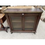 A REGENCY ROSEWOOD SIDE CABINET WITH TWO GLAZED DOORS, PIERCED BRASS GALLERY AND BRASS LION'S PAW