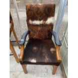 A MODERN OPEN ELBOW CHAIR COVERED IN COW HIDE