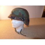 AN ARMY HELMET, WITH CAMOFLAGE COVER