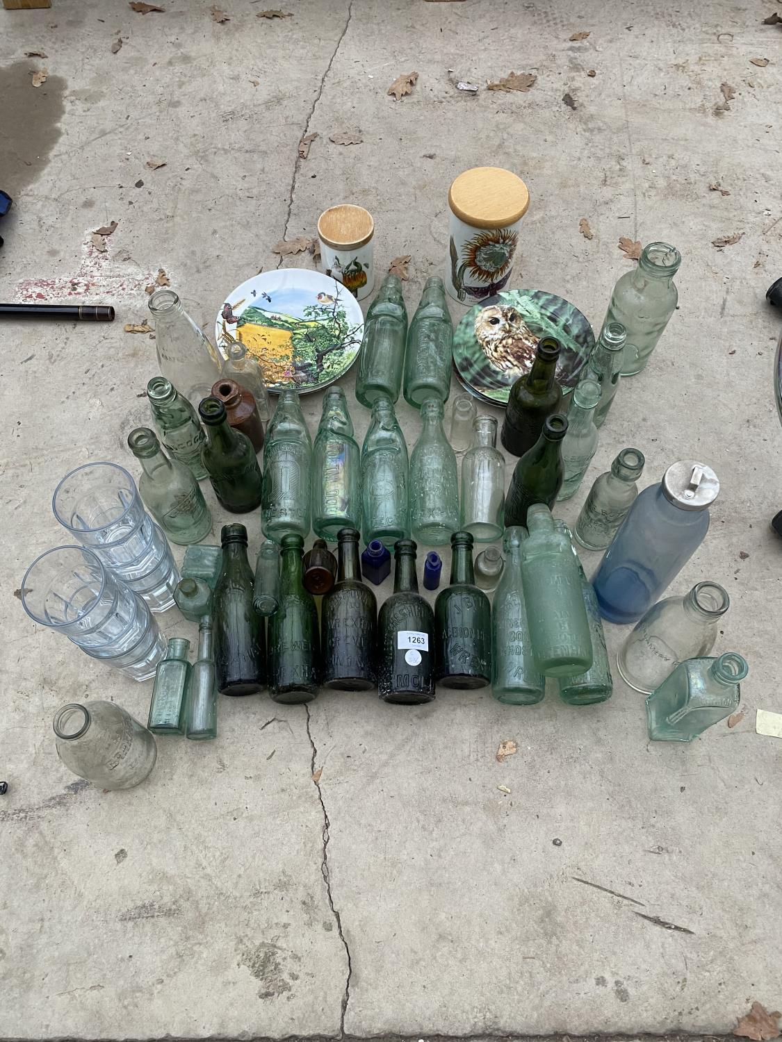 AN ASSORTMENT OF CERAMIC AND GLASS WARE TO INCLUDE A QUANTITY OF GREEN GLASS BOTTLES