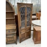 AN OLD CHARM OAK CORNER CABINET WITH TWO LOWER AND TWO UPPER LEAD GLAZED DOORS