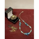 AN ORNATE METAL BROOCH WITH CENTRAL OPAQUE STONE AND A DELICATTE WHITE METAL AND TURQUOISE NECKLACE