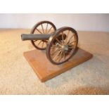 A BRASS BARRELED MODEL OF AN EARLY 19TH CENTURY NAPOLEONIC CANNON, MOUNTED ON A WOODEN CARRAIGE WITH