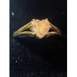 A 9 CARAT GOLD RING WITH A HEART SHAPED CLEAR STONE