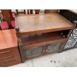 AN OAK OLD CHARM DINNER TROLLEY WITH GLAZED AND LEADED DOORS TO THE BASE