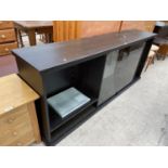 A MODERN EBONISED LOW LOUNGE UNIT WITH GLASS DOORS AND SHELVING, 80" WIDE