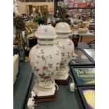 A PAIR OF DECORATIVE CERAMIC TABLE LAMPS WITH A FLORAL DESIGN