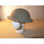 A WORLD WAR II PERIOD BRITISH STEEL HELMET AND LINER