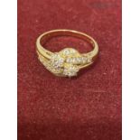 AN ORNATE 14 CARAT GOLD RING WITH CLEAR STONE POSSIBLY DIAMOND CHIPS